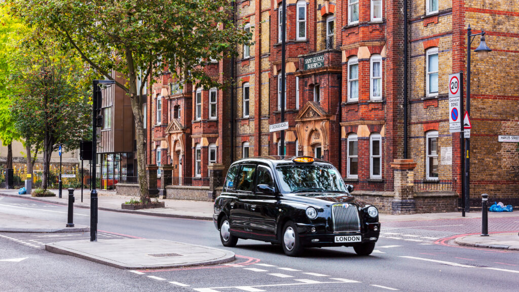 Black cab taxi driving down a street in Liverpool.